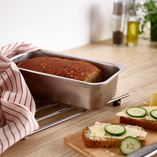 Molde de pan VINTERROCKA con pan horneado, de acero inoxidable, rectangular, sobre mesa de madera, toalla y bocadillos cerca.
