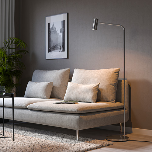 Sala de estar moderna con sofá SÖDERHAMN gris claro, almohadas, lámpara de pie, alfombra y planta.