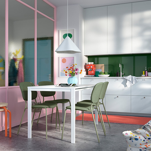 Comedor moderno con mesa VIHALS blanca, sillas verdes, detalles en rosa y lámpara colgante.