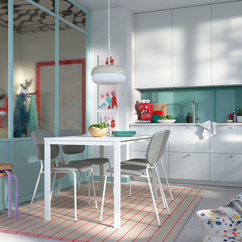 Cocina moderna con mesa blanca, sillas grises, alfombra roja, armarios turquesa.