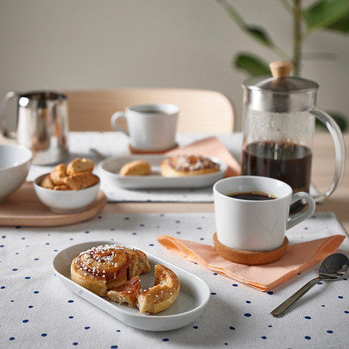 Desayuno con plato, bollería, café y cuencos.