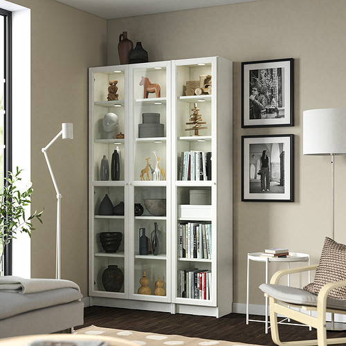 Estantería blanca BILLY en la sala de estar llena de decoración y libros junto a una gran ventana.