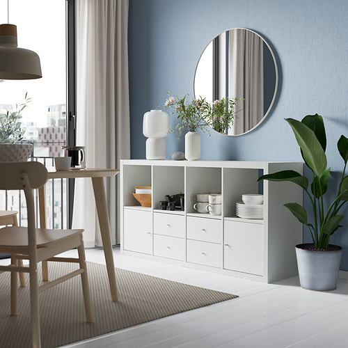 Elegante sala de estar con estanterías, espejo y decoración KALLAX blancos.
