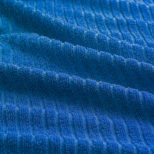 Toalla azul suave y afelpada con estampado de rayas, que muestra una textura de calidad.