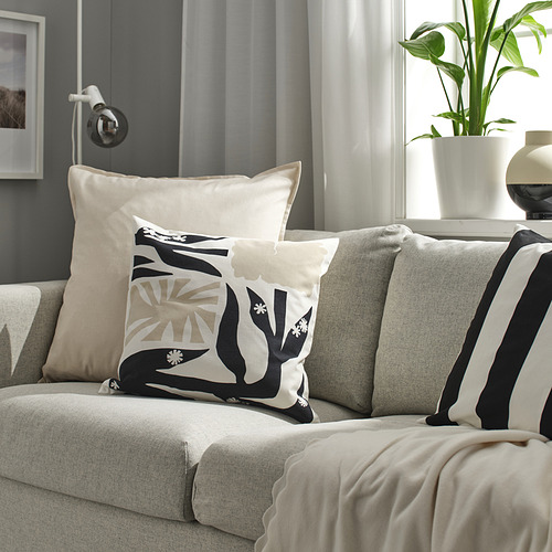 Sofá gris con cojines y almohadas GURLI, manta, planta.
