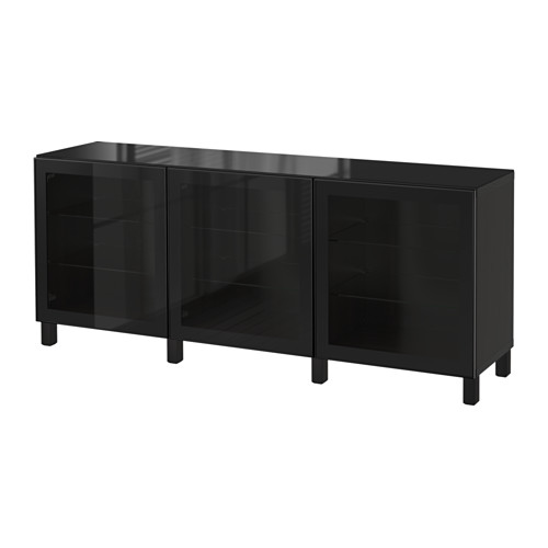 Mueble BESTÅ negro con puertas de cristal y patas negras.