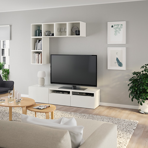 Sala de estar moderna con TV de pantalla plana en soporte BESTÅ, estanterías decoradas, arte y mesa de centro.