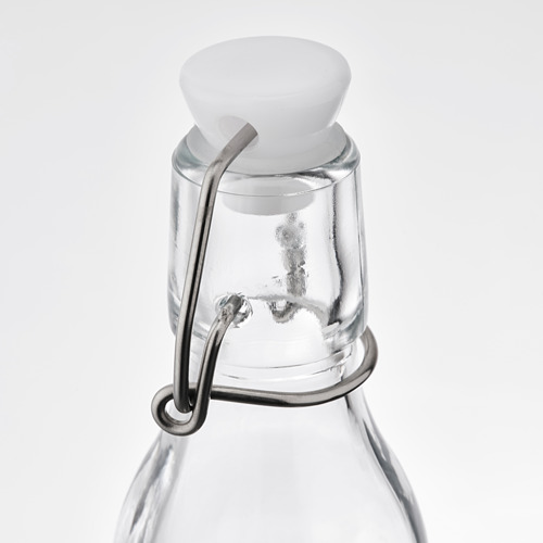 Botella de vidrio con tapa blanca y pinza metálica. Cierre hermético para mayor frescura.