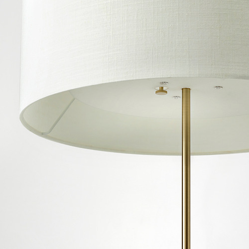 Lámpara cilíndrica con soporte de latón, elegante pantalla textil y base robusta. Diseño de calidad, materiales nobles.