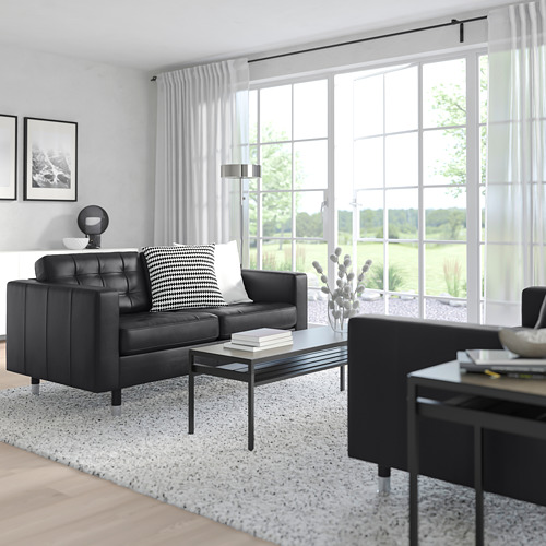 Sala de estar moderna con gran ventanal y silla negra LANDSKRONA, elegante mesa de centro, decoración elegante, espaciosa y luminosa.