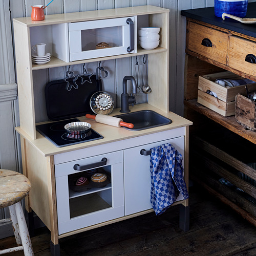 Cocina de juguete para niños, blanca con detalles en negro, incluye fregadero, estufa, horno y accesorios.