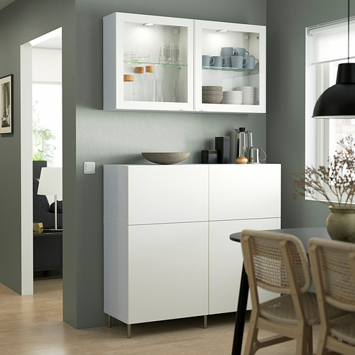 Comedor moderno con armario blanco y sillas de mimbre.