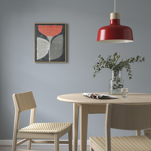 Arte abstracto BLODFLÄDER con marco de roble rojo/blanco. Cuelga sobre la mesa de comedor con sillas beige, iluminadas por una lámpara colgante roja.