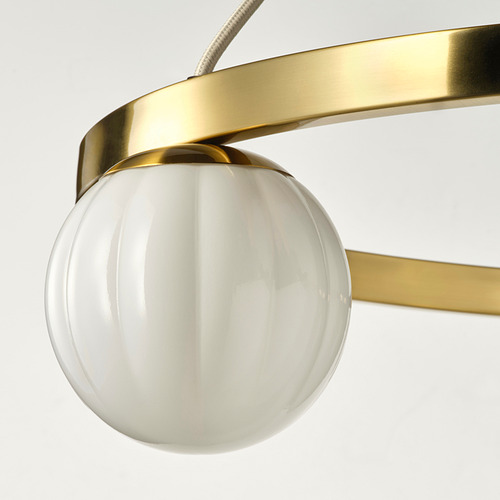 Primer plano de una elegante lámpara colgante con un marco de metal dorado y una sola pantalla de vidrio blanco elegantemente acanalada.
