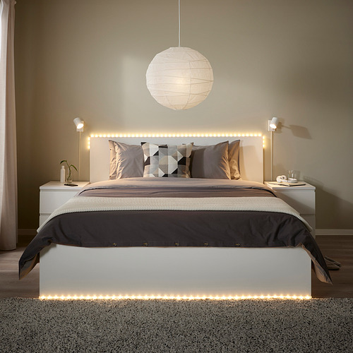 Dormitorio moderno con luces led, ropa de cama neutra y apliques.