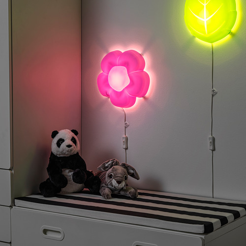 Dos peluches en un banco a rayas, lámpara de flores rosas, resplandor cálido.