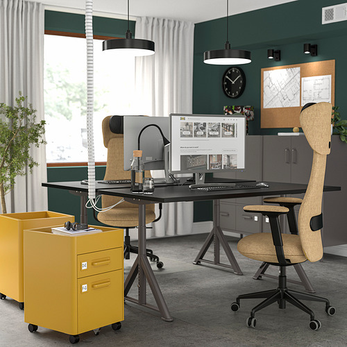 Moderna oficina con escritorios IDÅSEN, armarios amarillos, sillas ergonómicas, monitores y lámparas colgantes.