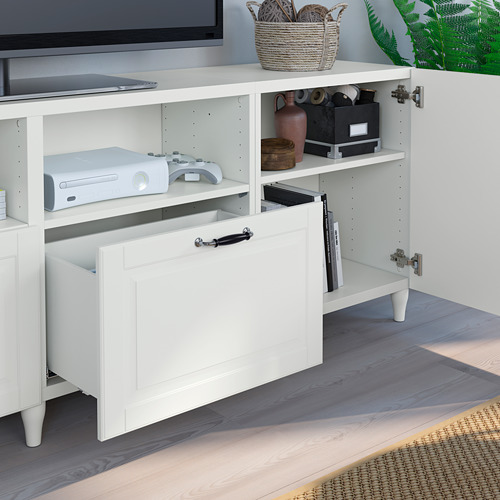 Mueble de tv BESTÅ blanco con estantes ajustables, cajón abierto y gestión de cables. Almacena consolas de juegos, controles remotos y decoración.
