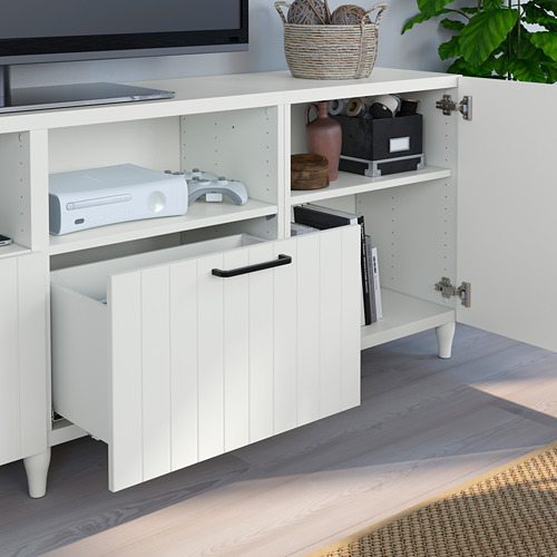 Mueble de tv blanco BESTÅ con estantes ajustables, cajones abiertos y gestión de cables, que alberga una consola de juegos y accesorios.