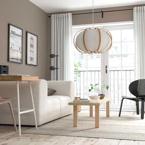Sala de estar moderna con muebles ligeros, lámpara TAGGTOFS y vista al balcón.
