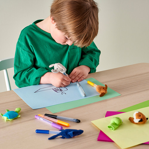 Un niño usa títeres de dedo y marcadores en papel.