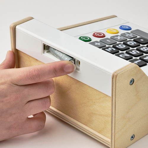 El niño presiona el botón en el juguete de la caja registradora con la pantalla de la calculadora.