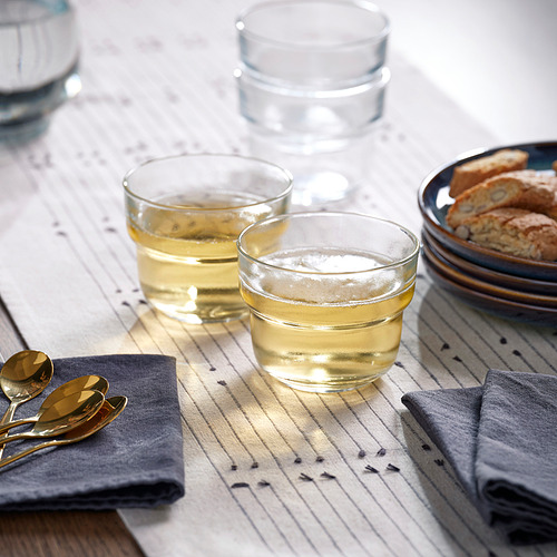Tres vasos llenos de líquido sobre un paño a rayas, acompañados de un plato de pan y dos cucharas.
