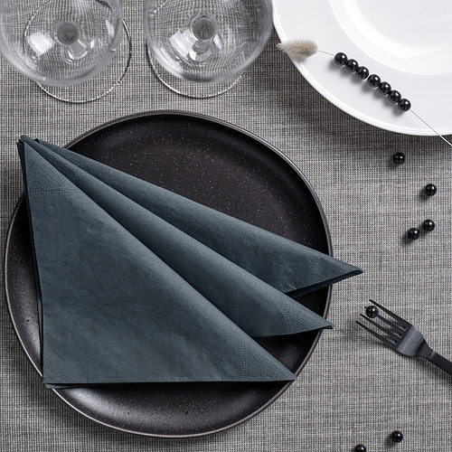 Servilletas negras, plato, vasos, tenedor, abalorios sobre lino gris.
