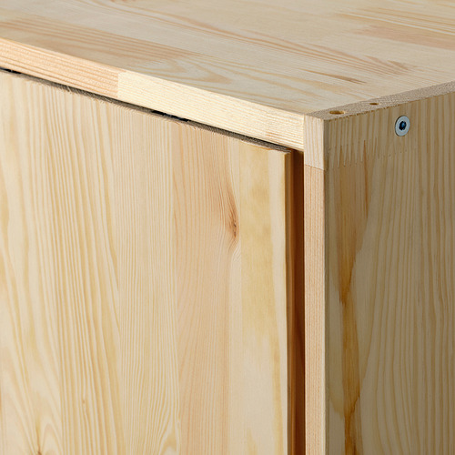 Primer plano de muebles IVAR robustos de madera de pino. Muestra bordes lisos y un elegante mecanismo de deslizamiento.