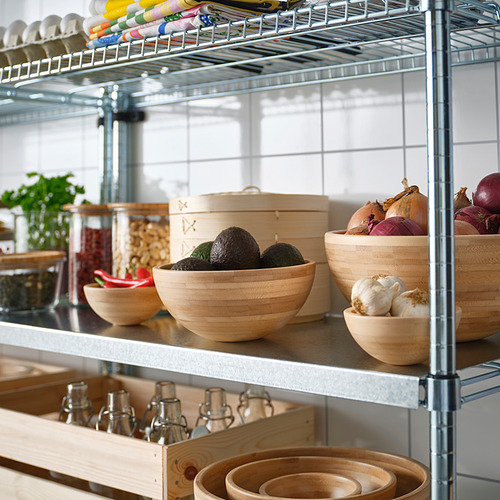 Estante metálico con tazones: aguacates, cebollas, ajos y frascos. Los cuencos de madera son apilables.