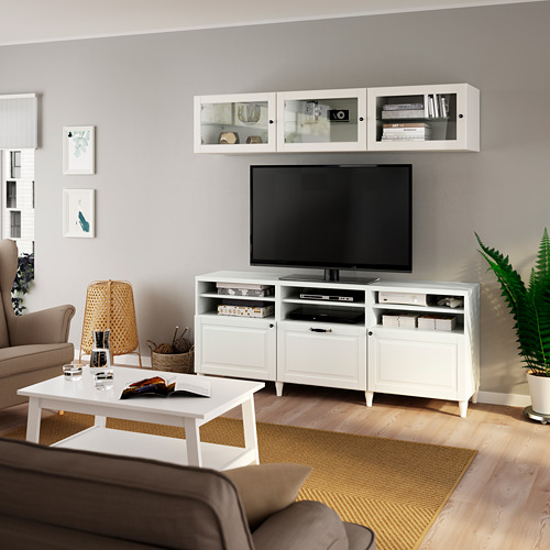 Sala de estar moderna con mueble de televisión BESTÅ, sofá marrón y vegetación.