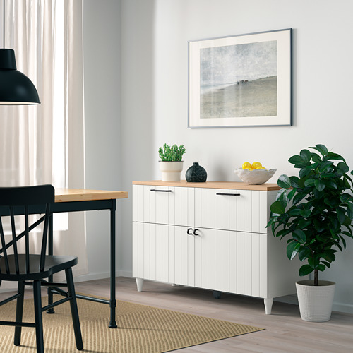 Sala de estar moderna con aparador BESTÅ, plantas, frutas y juego de comedor.