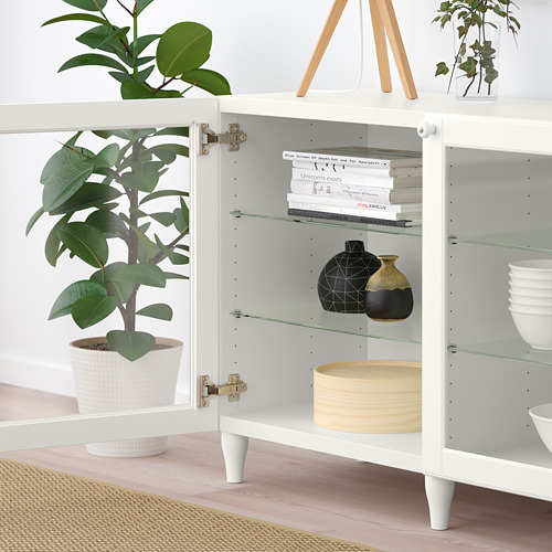 El aparador blanco con puertas de vidrio muestra libros, jarrones y tazones, mostrando almacenamiento organizado y estantes ajustables.