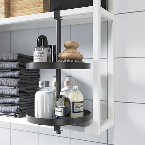 Estantería de baño giratoria con botellas y toallas.