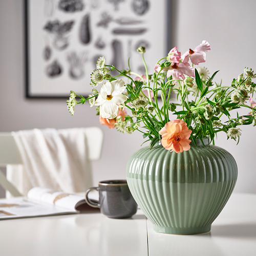Jarrón PELARBJÖRK, gris verdoso, gres, bulboso y acanalado, sostiene flores, en la mesa con taza, silla, obra de arte.