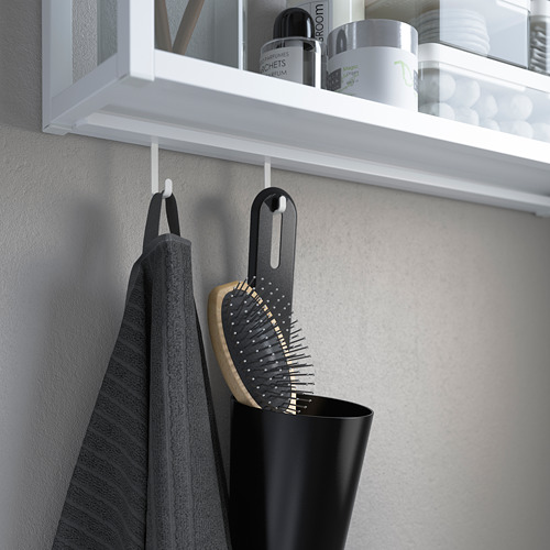 Estante blanco con ganchos, toalla gris y cepillo negro. Ganchos unidos a las ranuras de los estantes para colgar.