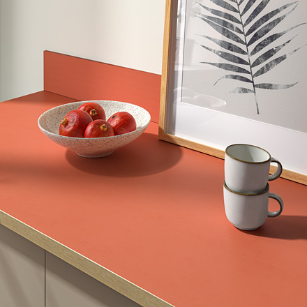 Una encimera de cocina moderna con un cuenco de frutos rojos y tazas blancas apiladas, que muestra su diseño elegante y fácil de limpiar.