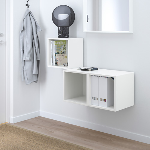 Mueble alto blanco EKET. Almacenamiento pequeño y moderno con estantería de museo, secciones abiertas y cerradas. Cuelga alto, cerca de un perchero.