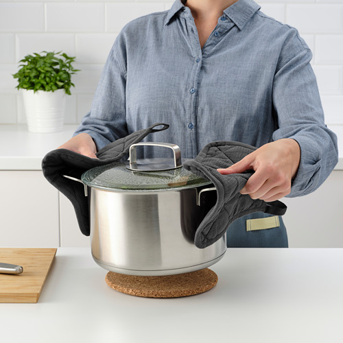 Persona sosteniendo la tapa y el paño en la cocina