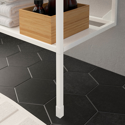 Patas de estante ENHET blancas ajustables, con caja de almacenamiento de madera con botellas, colocadas sobre baldosas hexagonales oscuras.