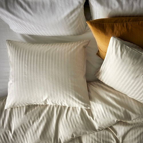 Cama con juego de edredón de rayas gris claro y almohada amarilla. Estampado de rayas, tejido suave.