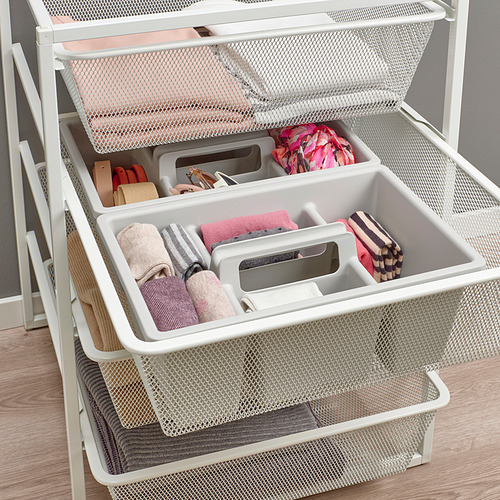 Cajones de almacenamiento de malla blanca llenos de ropa y accesorios cuidadosamente doblados, organizados y apilados verticalmente para un uso eficiente del espacio.