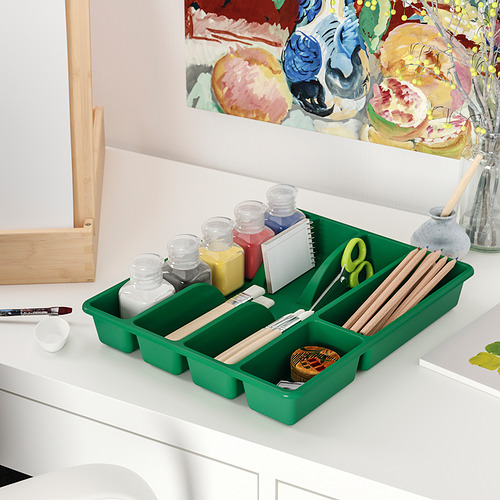 La bandeja verde SMÄCKER organiza los materiales de arte y encaja bien en una mesa.
