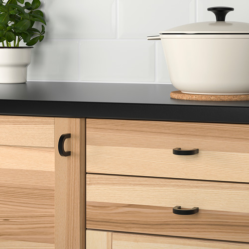 Cocina moderna con cajones de madera clara y tiradores metálicos.
