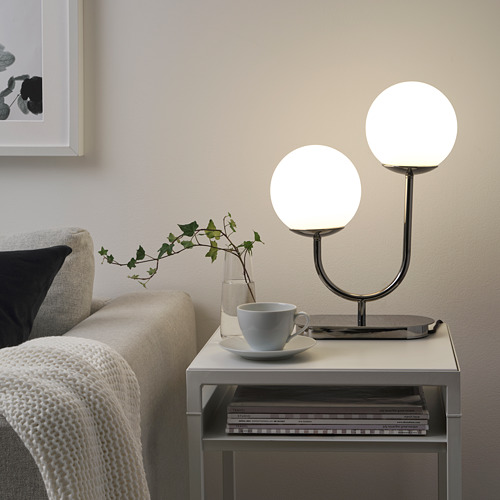 Acogedor rincón de sala de estar con lámpara, taza y planta SOLHETA.