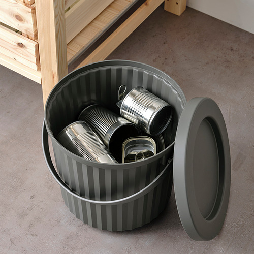 Cubo de basura gris abierto a rayas sin tapa, que contiene latas de metal, adecuado para residuos pequeños como bombillas o pilas.