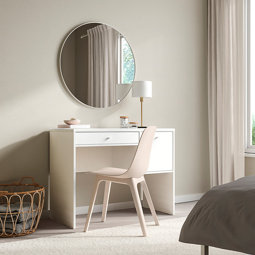 Dormitorio minimalista con tocador SYVDE blanco. Espejo redondo, lámpara, cesta de mimbre. Diseño limpio y sencillo. Cajones de cierre suave. Alfombra beige.