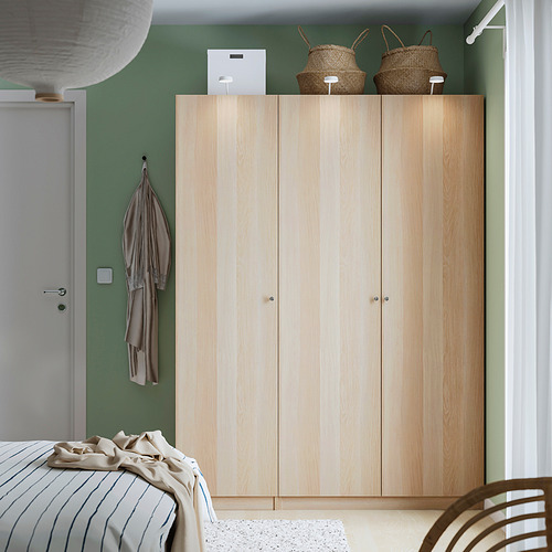 Dormitorio organizado con armario PAX, pared verde y lámpara colgante.