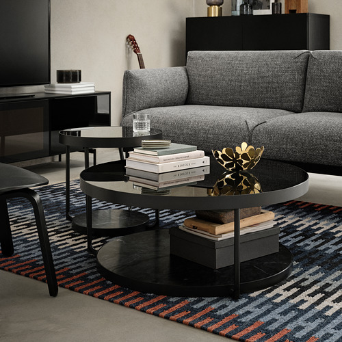Sala de estar con mesa de centro FRÖTORP, sofá gris, alfombra de colores.