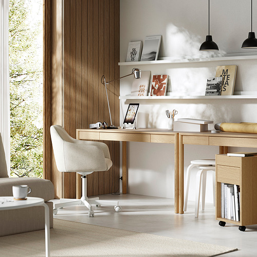 Moderna oficina en casa con escritorio de madera clara, silla blanca y estantes. Chapa de roble, diseño limpio y accesorios elegantes.